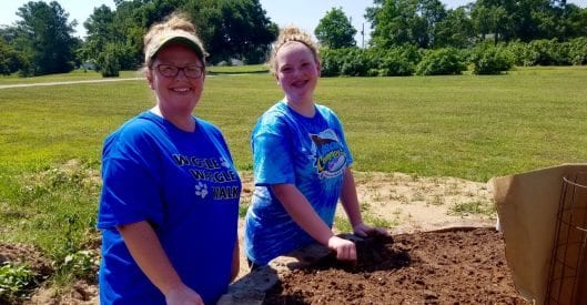 girl scout and mother preparing garden bed