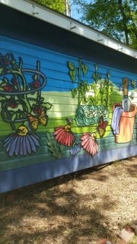 shed painted with flowers and gardening items